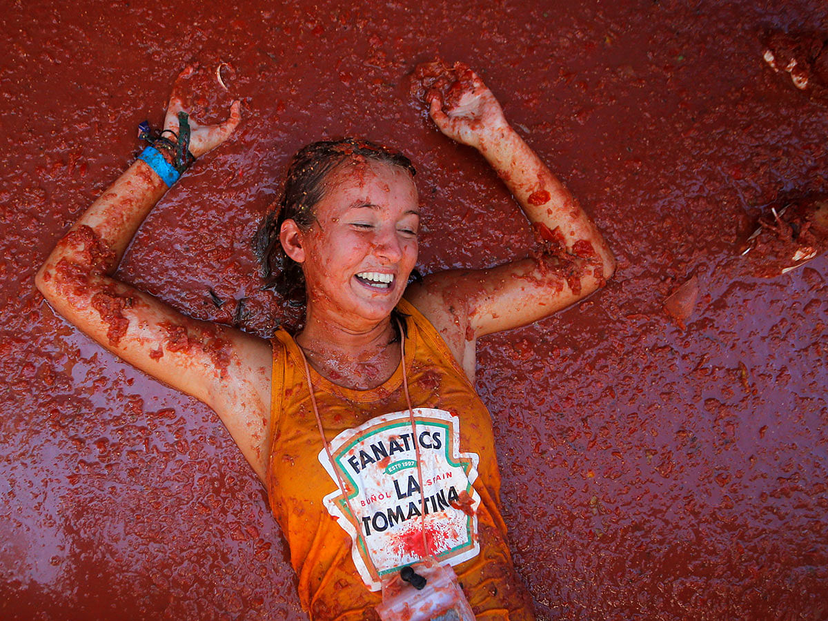 A reveller lies in tomato pulp during the annual `La Tomatina` tomato food fight festival in Bunol, near Valencia, Spain, on 28 August 2019. Photo: Reuters