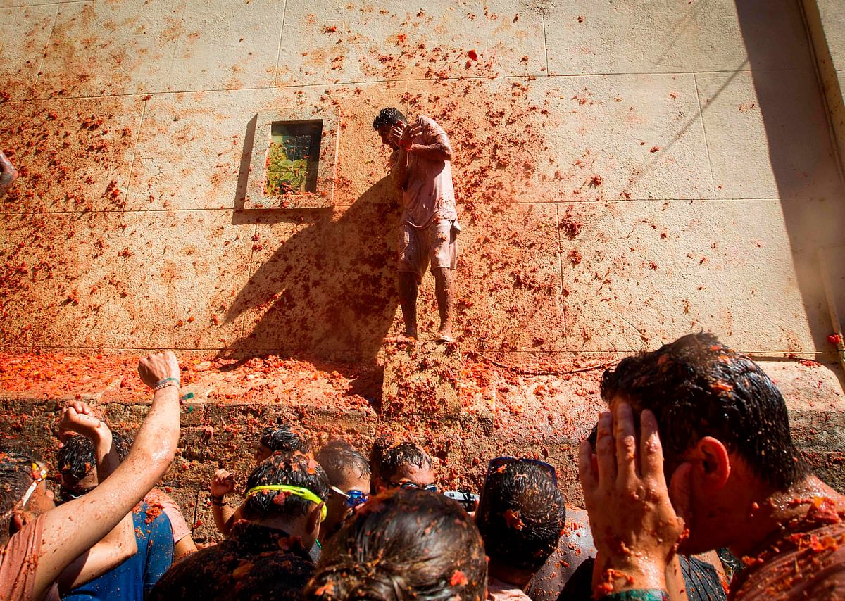 Revellers covered in tomato pulp take part in the annual `Tomatina` festival in the eastern town of Bunol, on 28 August 2019. Photo: AFP