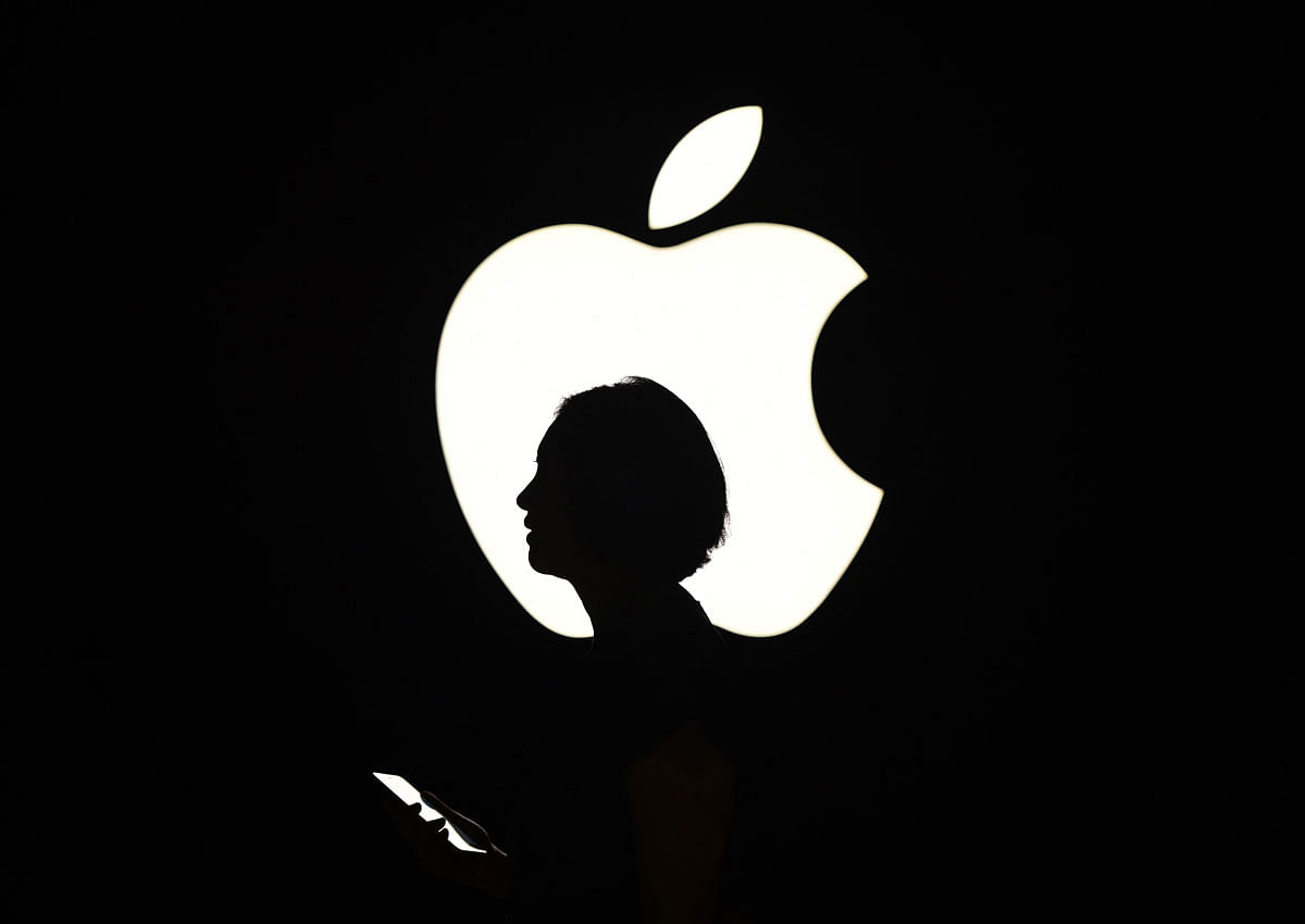 n this file photo taken on 9 September 2015 a reporter walks by an Apple logo during a media event in San Francisco, California. Photo: AFP