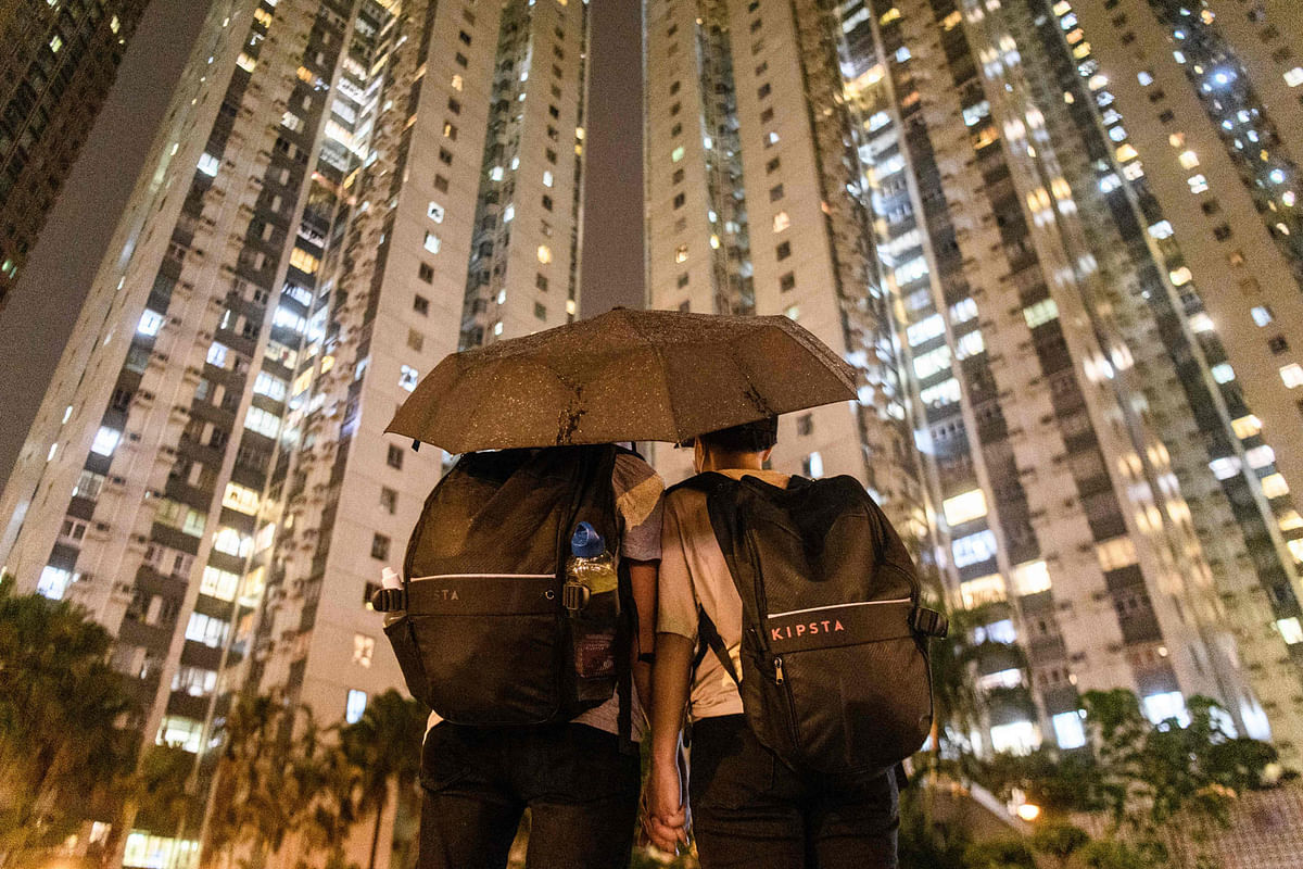 In this picture taken on 25 August 2019, Abby (centre L), 19, and her boyfriend Nick, 20, pose in front of residential buildings after they attended a protest in Tsuen Wan, an area in the New Territories in Hong Kong. Photo: AFP