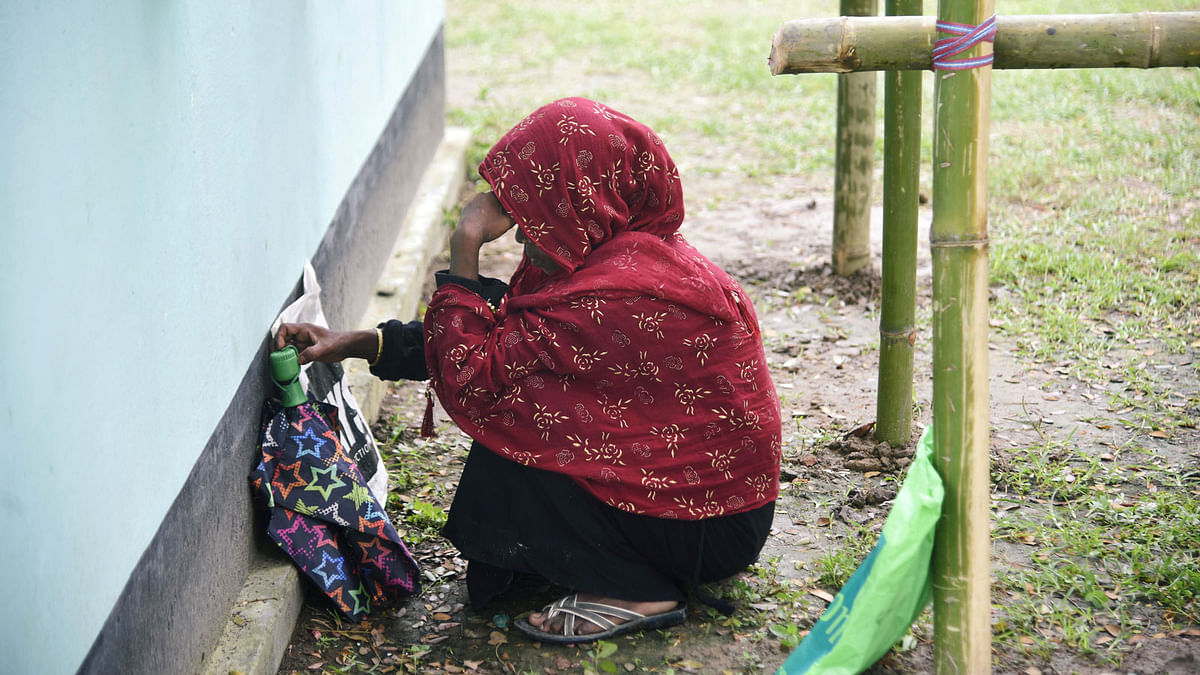 A woman waits to check her name on the draft list of the National Register of Citizens (NRC), as she sits outside an NRC centre in Rupohi village, Nagaon district, northeastern state of Assam, India on 31 August 2019. Photo: Reuters