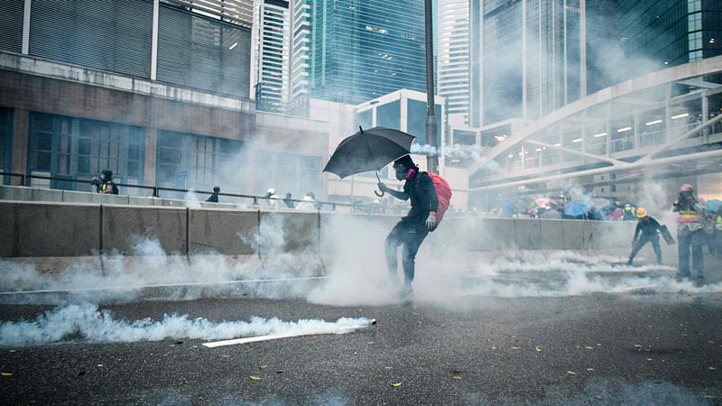 Protesters react after police fired tear gas outside the government headquarters in Hong Kong on Saturday. Chaos engulfed Hong Kong’s financial heart on Saturday as police fired tear gas and water cannon at petrol bomb-throwing protesters, who defied a ban on rallying. Photo: AFP