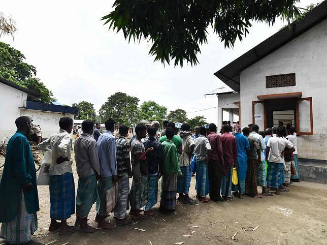 People stand in a queue to check their names on the final list of the National Register of Citizens (NRC) in an office in Pavakati village of Morigoan district, some 70 kms from Guwahati, the capital city of India`s northeastern state of Assam on 31 August 2019. Photo: AFP
