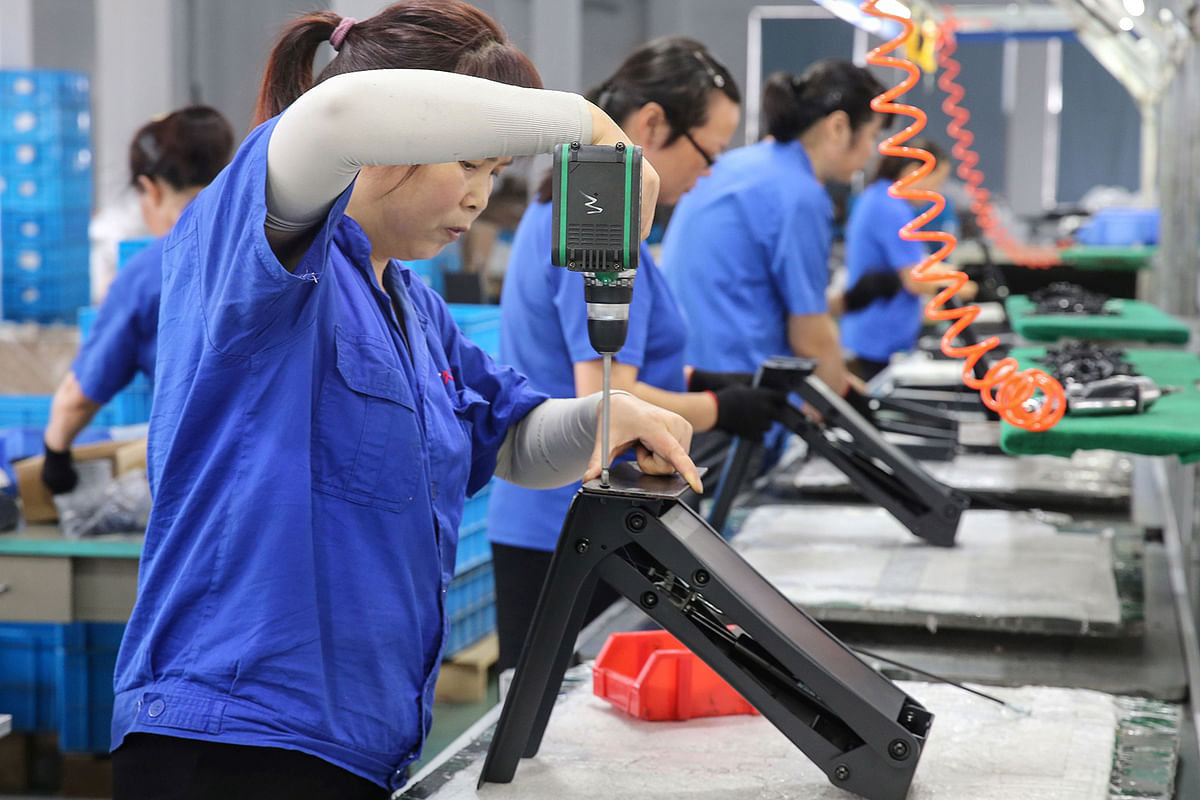 Workers produce desks for export to the US, France, Germany and other countries, at a factory in Nantong in China`s eastern Jiangsu province on 4 September 2019. Photo: AFP