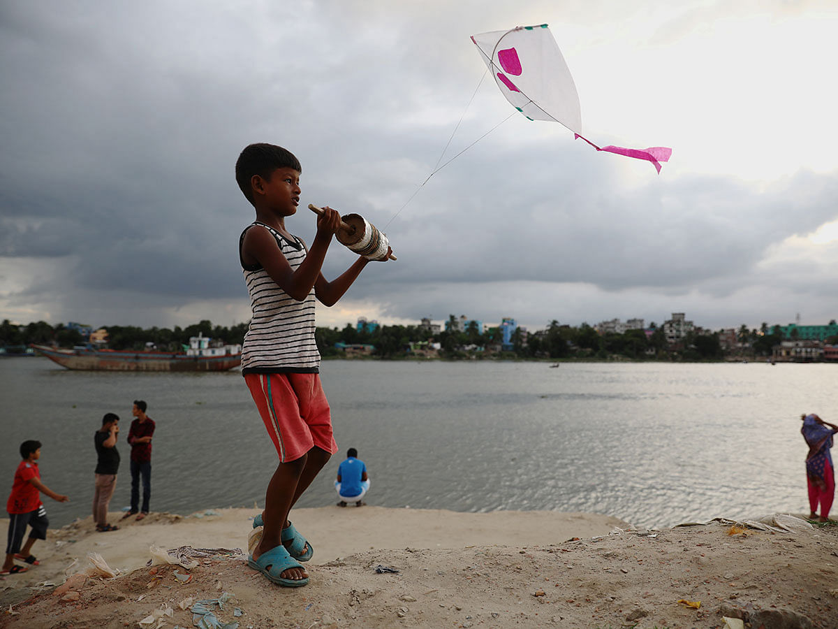 A boy flies a kite in the bank of the Buriganga river in Dhaka, Bangladesh, 4 September 2019. Photo: Reuters