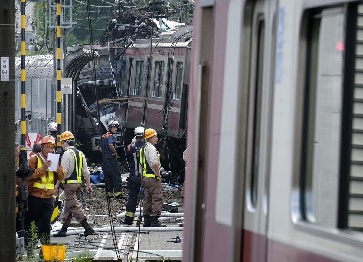 The mangled wreckage of a truck (centre L) is seen following a collision with a train at a crossing in Yokohama, Kanagawa Prefecture on Thursday. Photo: AFP