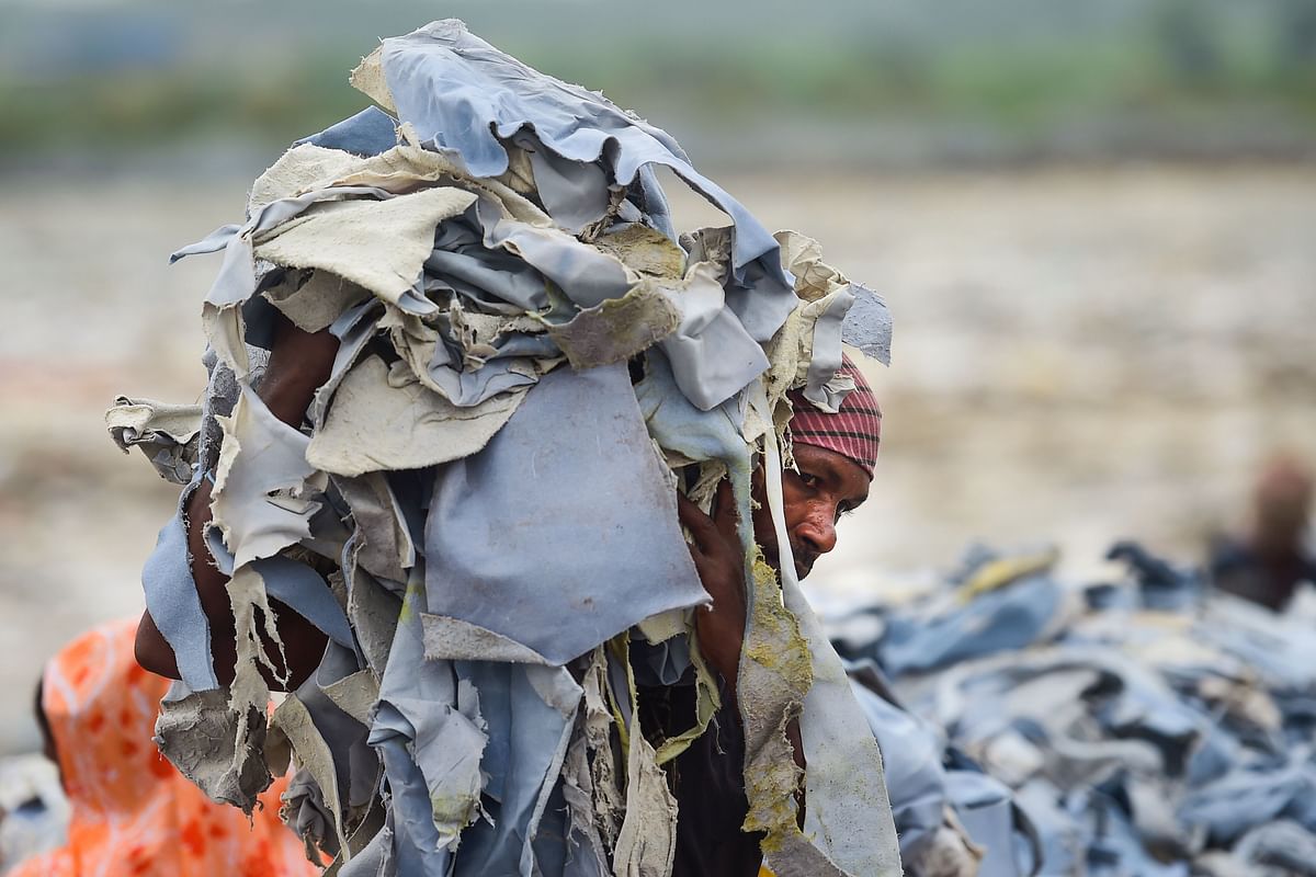 Bangladeshi labourer carries a pile of tannery waste at an export processing zone in Savar on 2 September 2019. Photo: AFP