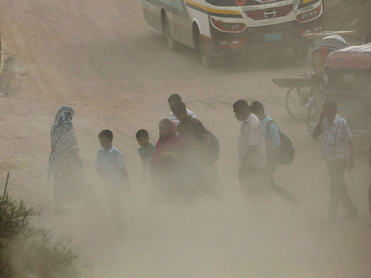 People cross a dusty road in Dhaka, Bangladesh on 31 August 2019. Photo: Reuters