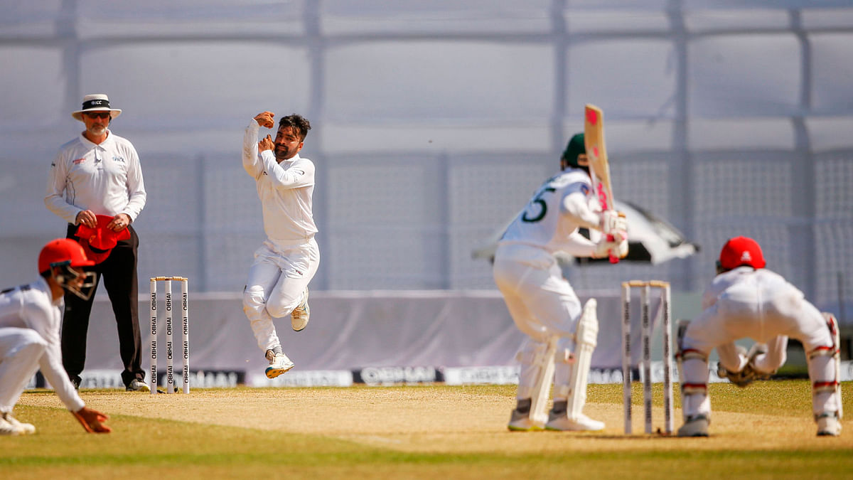 Afghanistan`s cricketer Rashid Khan (2L) delivers a ball during the second day of the one-off cricket Test match between Bangladesh and Afghanistan at the Zohur Ahmed Chowdhury Stadium in Chittagong on Friday. Photo: AFP