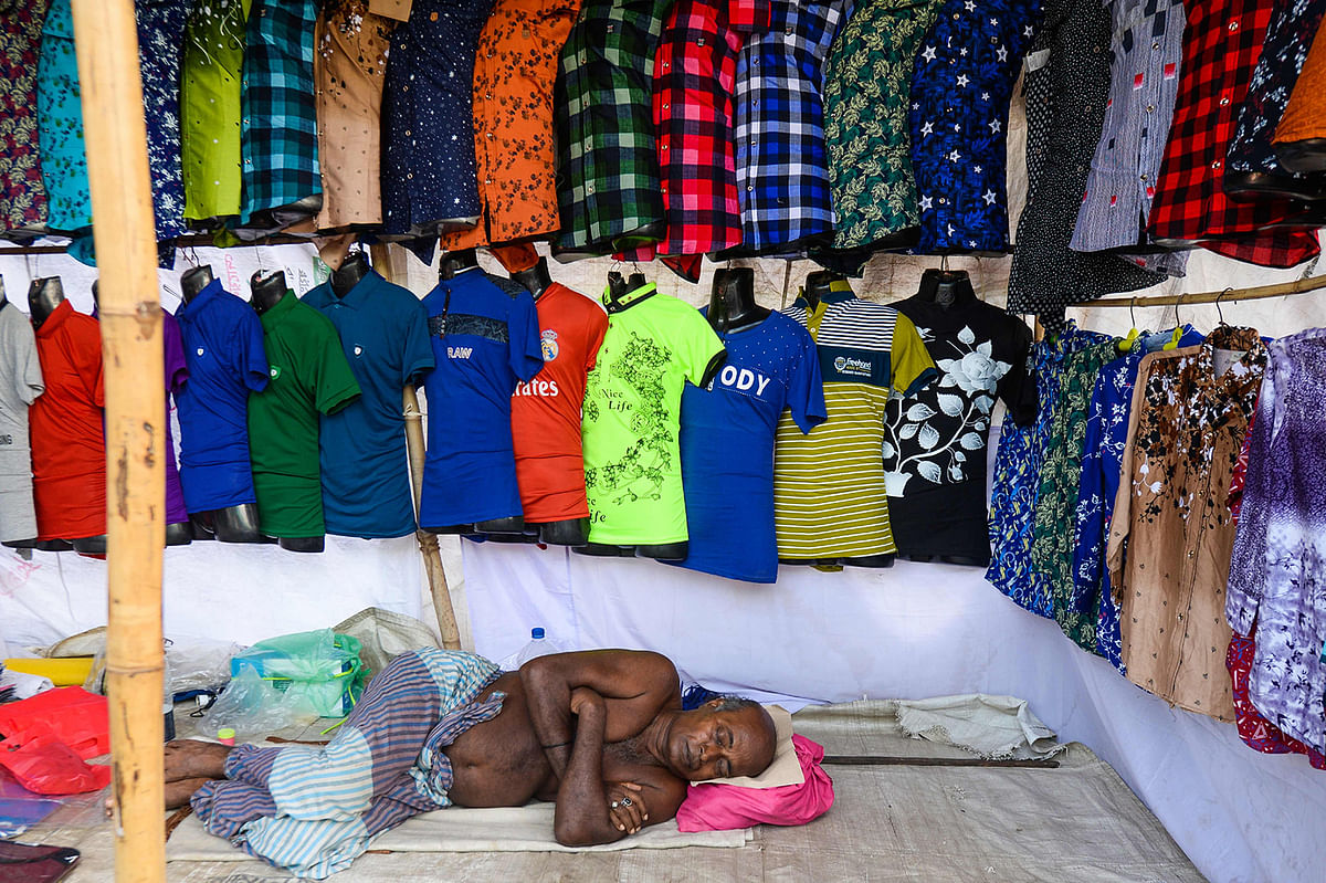 A vendor sleeps at his shop in Karwan Bazar wholesale market in Dhaka on 8 September, 2019. Photo: AFP