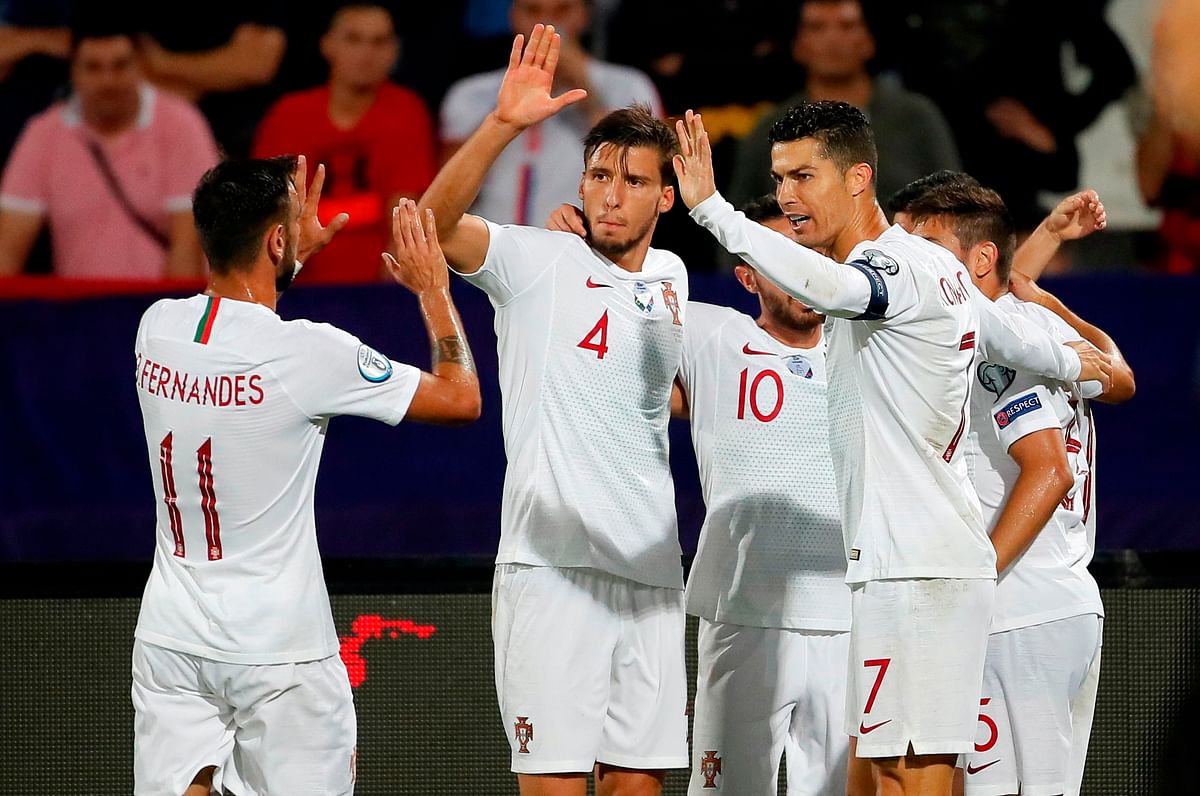 (FromL) Portugal`s midfielder Bruno Fernandes, Portugal`s defender Ruben Dias and Portugal`s forward Cristiano Ronaldo celebrate a goal during the EURO 2020 football qualification match between Serbia and Portugal in Belgrade, Serbia, on Saturday. Photo: AFP