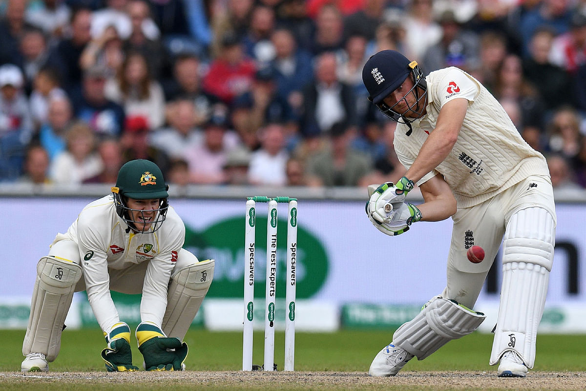 England`s Jos Buttler (R) plays a shot as Australia`s captain Tim Paine keeps wicket during play on the fifth day of the fourth Ashes cricket Test match between England and Australia at Old Trafford in Manchester, north-west England on 8 September, 2019. Photo: AFP