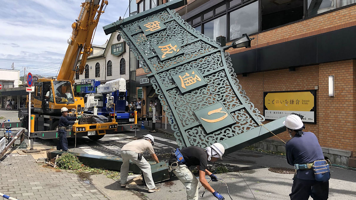 Workers remove a fallen signboard hit by typhoon Faxai in Kamakura, Kanagawa prefecture on 9 September 2019. A powerful typhoon with potentially record winds and rain battered the Tokyo region on 9 September, sparking evacuation warnings to tens of thousands, widespread blackouts and transport disruption. Photo: AFP