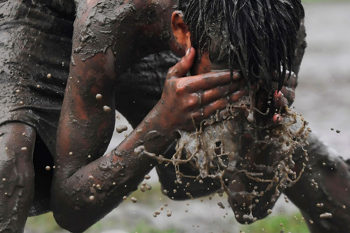 A boy washes his face during a game of Kabaddi on water logged grounds in Kolkata on 8 September 2019. Photo: AFP