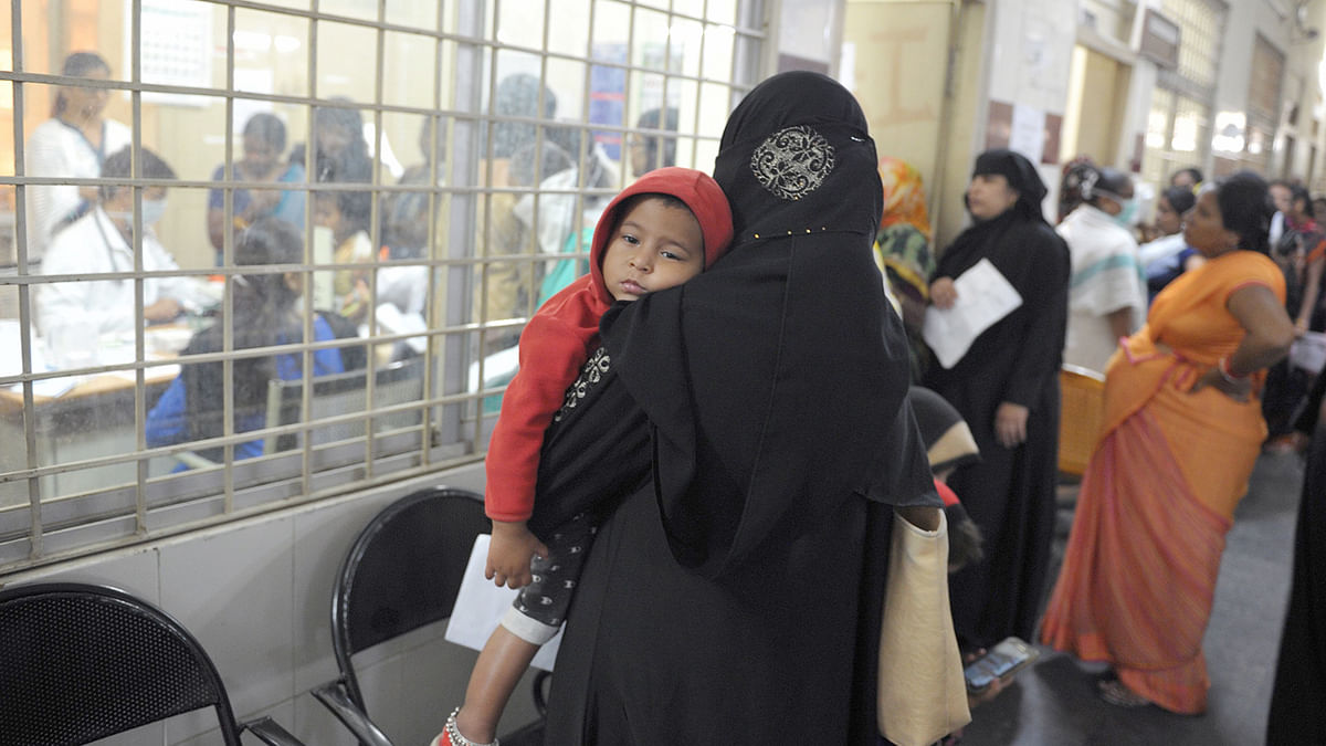 A woman hold her child as they wait to consult with a doctor in the out-patient wing of the Government Gandhi Hospital in Secunderabad, the twin city of Hyderabad, on 6 September 2019, as patients flooded hospitals in Telangana with cases of dengue fever. This photo has been used symbolically with this report. Photo: AFP