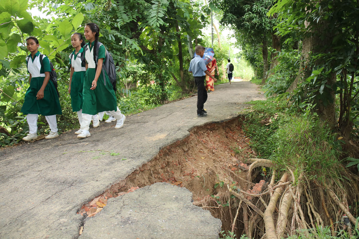 Pedestrians walk past a crack of a road at Milanpur, Khagrachhari, 9 September 2019. Photo: Nerob Chowdhury