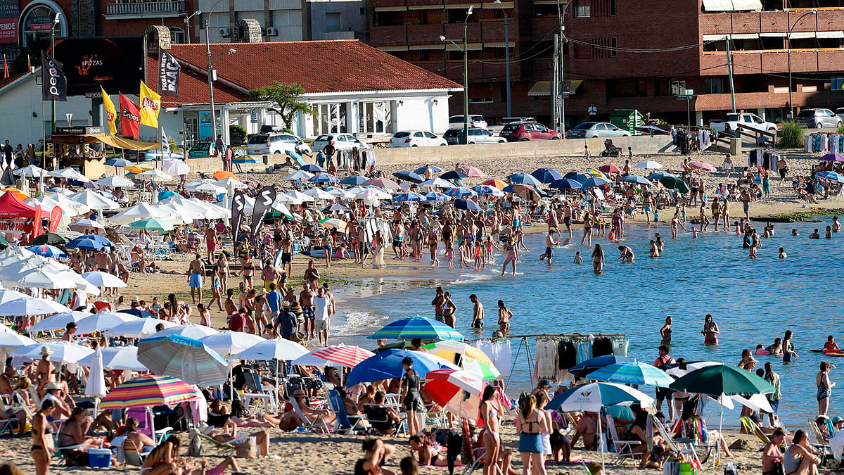 In this file photo taken on 16 January 2019, tourists enjoy the sun at La Mansa beach in Punta del Este, Uruguay. The exchange crisis that shakes Argentina set off alarms in neighboring Uruguay, where government, businessmen, presidential candidates and ordinary people wonder where the effects of the collapse will impact. Photo: AFP