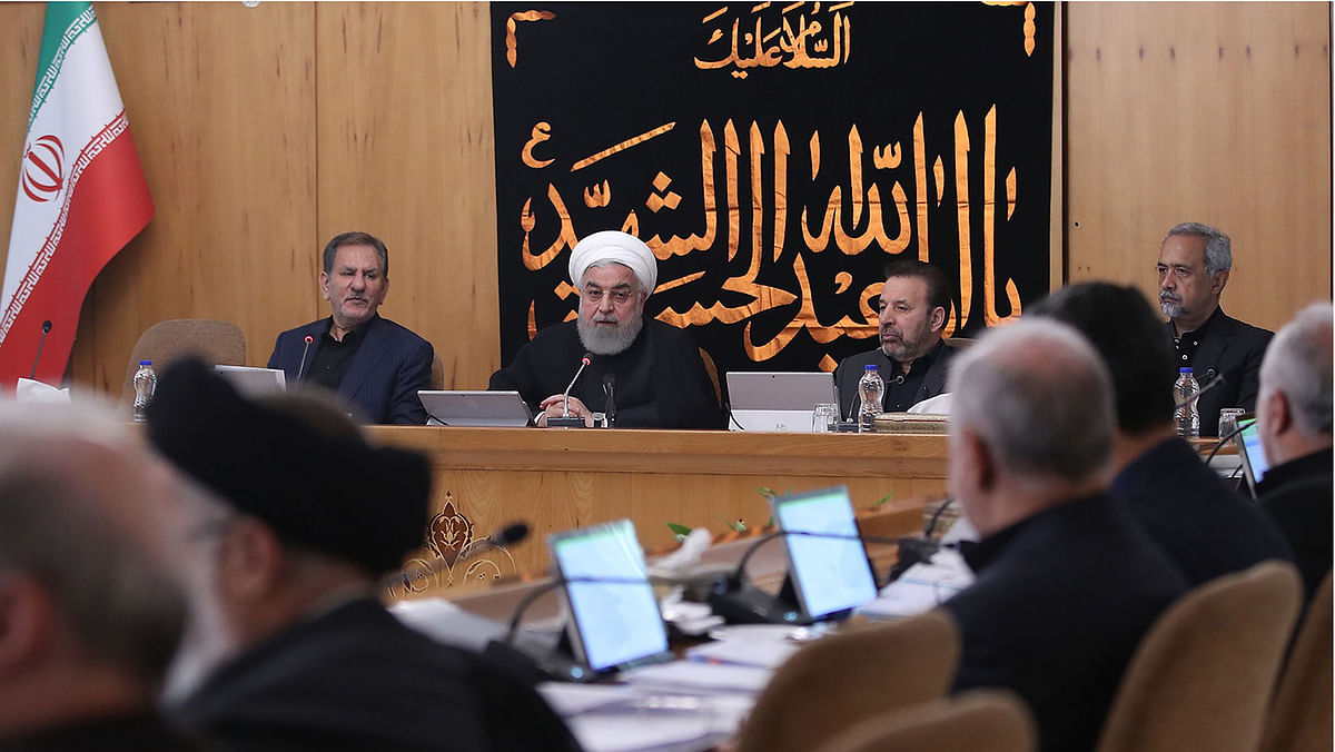 A handout picture provided by the Iranian presidency on 11 September shows president Hassan Rouhani (C) chairing a cabinet meeting in the capital Tehran, with a banner behind him reading in Arabic `O martyr Abu al-Abbas al-Hussein`, hung up during the Ashura mourning period and referring to the prophet Mohamed`s grandson Imam Hussein ibn Ali. Photo: AFP