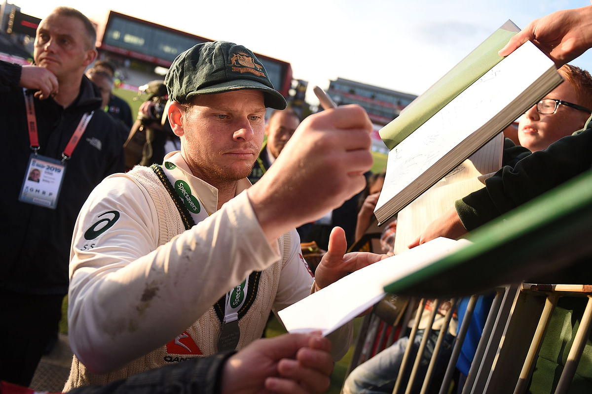Australia`s Steve Smith signs autographs for fans their victory in the fourth Ashes cricket Test match between England and Australia at Old Trafford in Manchester, north-west England on 8 September. AFP file photo