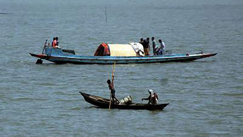 A boat and a trawler sailing on Nikli haor in Nikli upazila of Kishoreganj. Photo: Tafsilul Aziz.