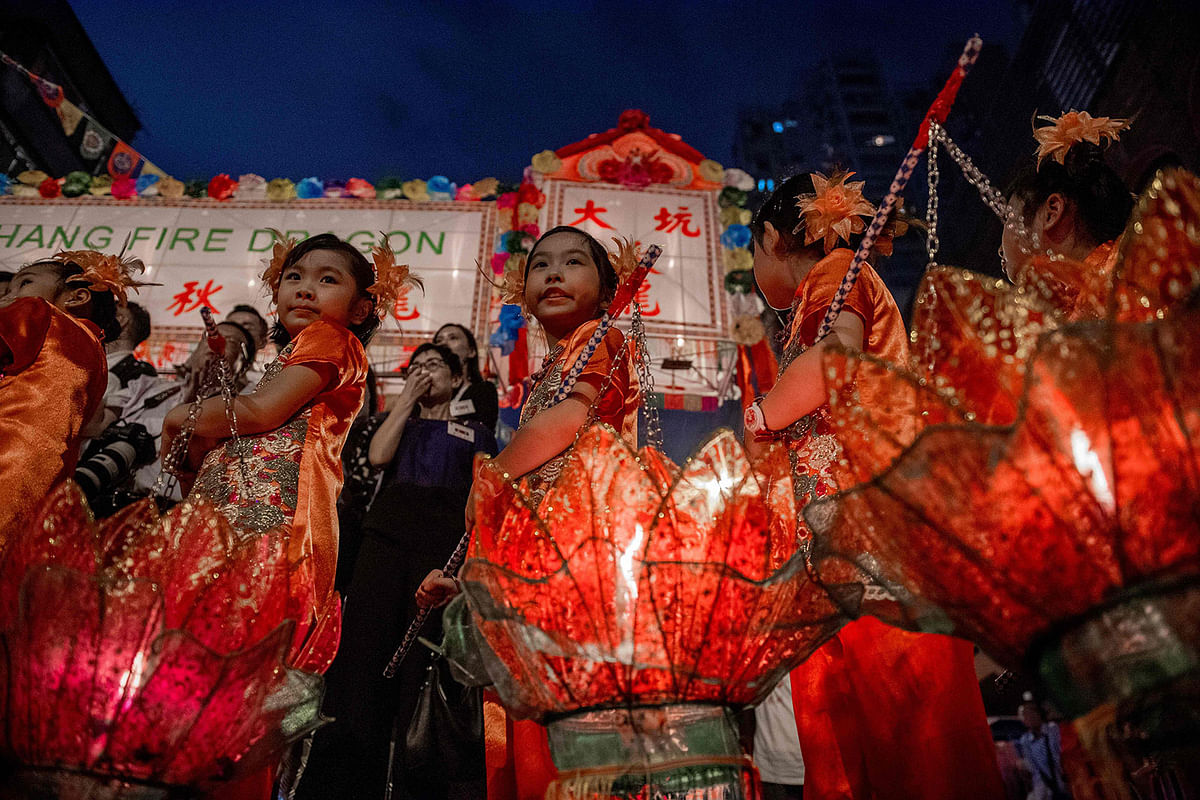 Young girls with lotus lanterns take part in the annual Tai Hang `fire dragon` event, one of the highlights of the city`s mid-autumn festival, in Hong Kong on 12 September, 2019. Photo: AFP