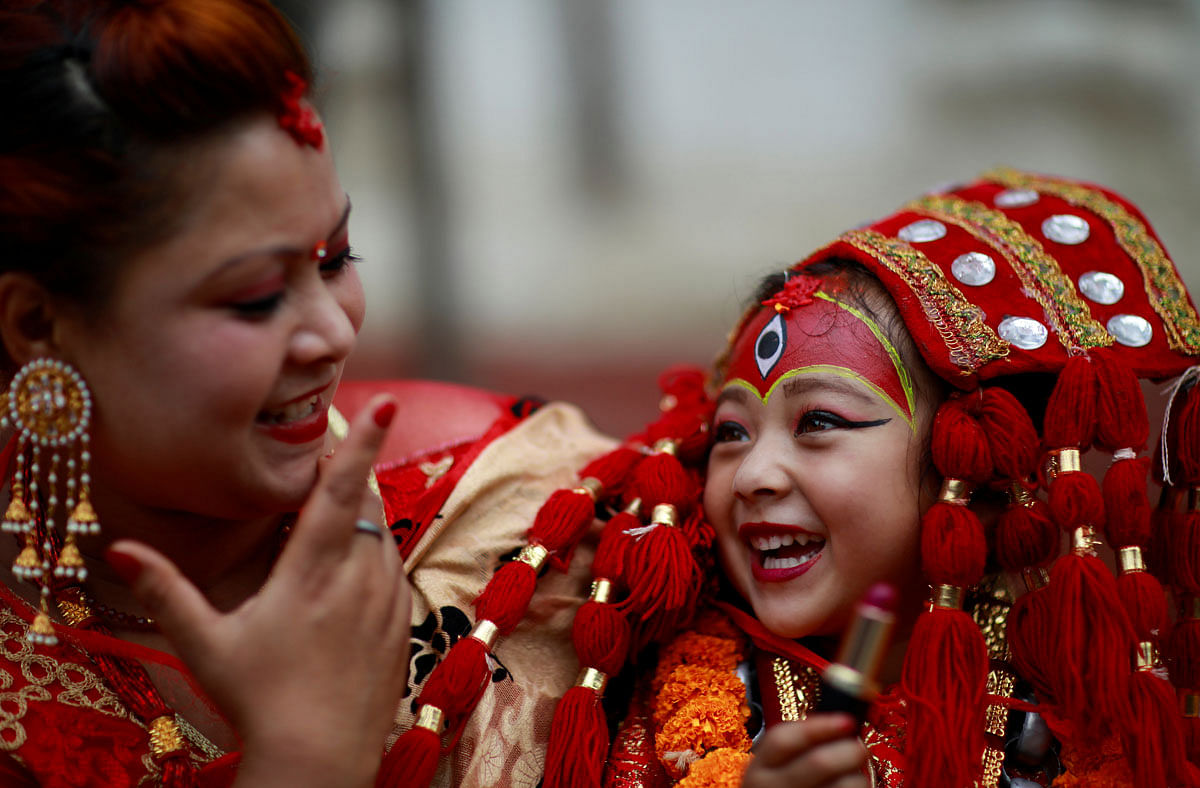 A young girl dressed as the Living Goddess Kumari smiles as she speaks with her mother during the Kumari Puja festival, in which young girls pose as the Living Goddess Kumari and are worshipped by people in belief that their children will remain healthy, in Kathmandu, Nepal on 11 September 2019. Photo: Reuters