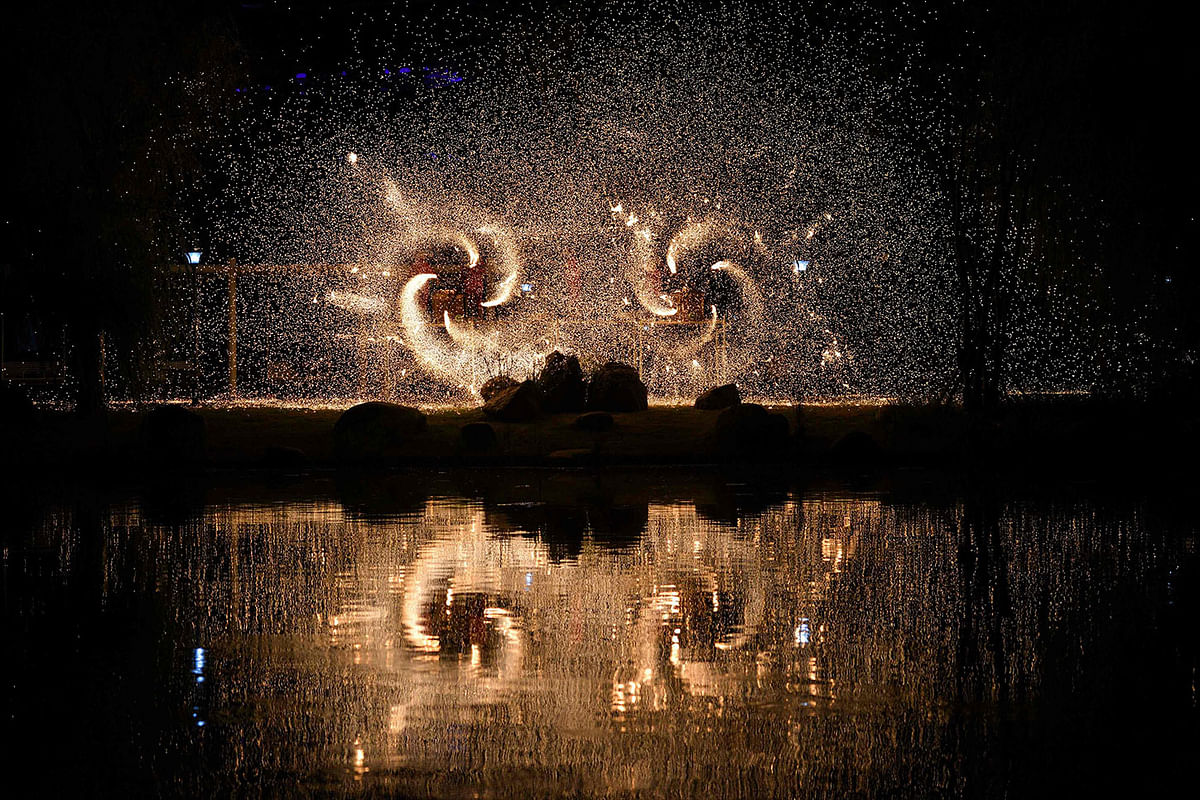 his photo taken on 13 September 2019 shows sparks created by molten iron water being splashed during a performance to celebrate the mid-autumn festival in Fuyang in China`s eastern Anhui province. Photo: AFP