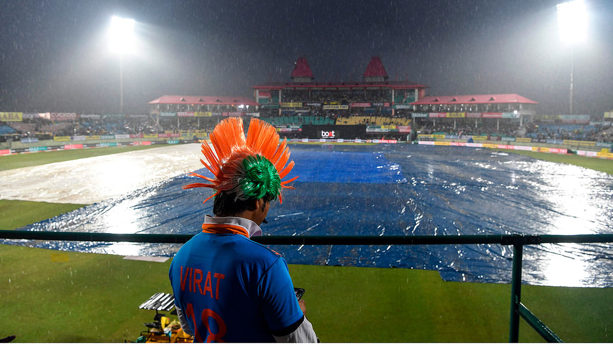 A cricket fan looks at his mobile phone as he stands on the grandstand before the start of the first Twenty20 international cricket match of a three-match series between India and South Africa at Himachal Pradesh Cricket Association Stadium in Dharamsala on 15 September 2019. Photo: AFP