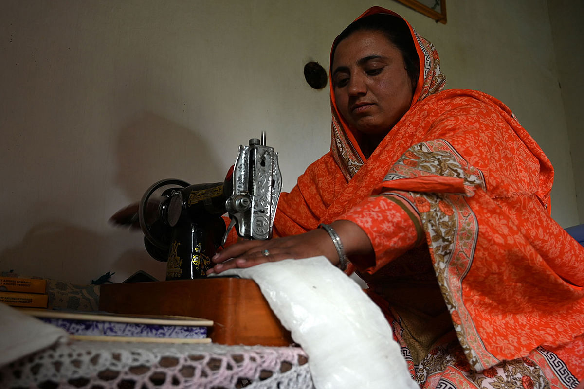 In this picture taken on 18 May 2019, Pakistani woman Hajra Bibi makes a sanitary pad with a sewing machine at her home in Booni village in Chitral. Photo: AFP