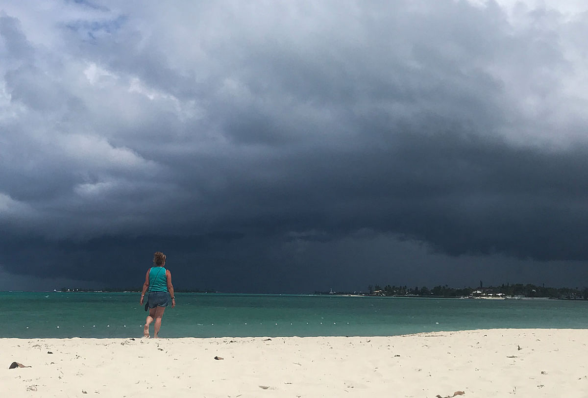 A woman walks on the beach as a storm approaches in Nassau, Bahamas, on 12 September 2019. Photo: AFP