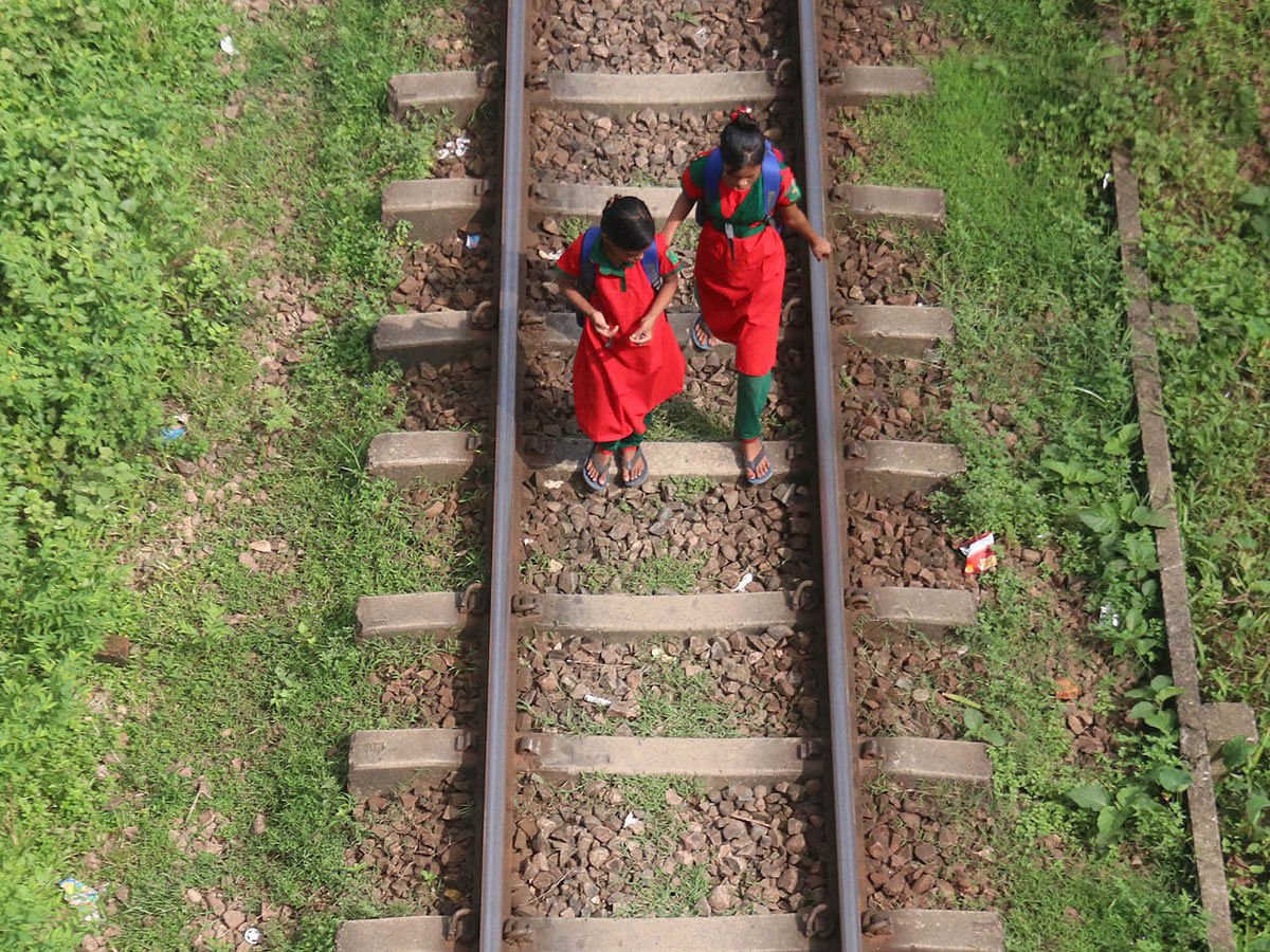 Two children walk along a railway line in Dakkhin Surma, Sylhet on 15 September 2019. Photo: Anis Mahmud