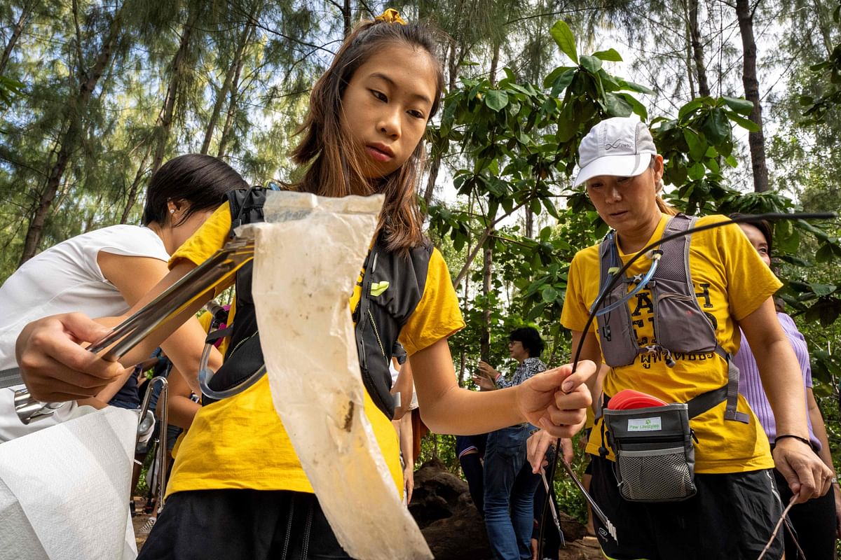 In this picture taken on August 12-year-old Ralyn Satidtanasarn, known by her nickname Lilly, collects plastic waste during the Trash Hero cleaning initiative at the Khung Bang Kachao urban forest and beach in Bangkok. Photo: AFP
