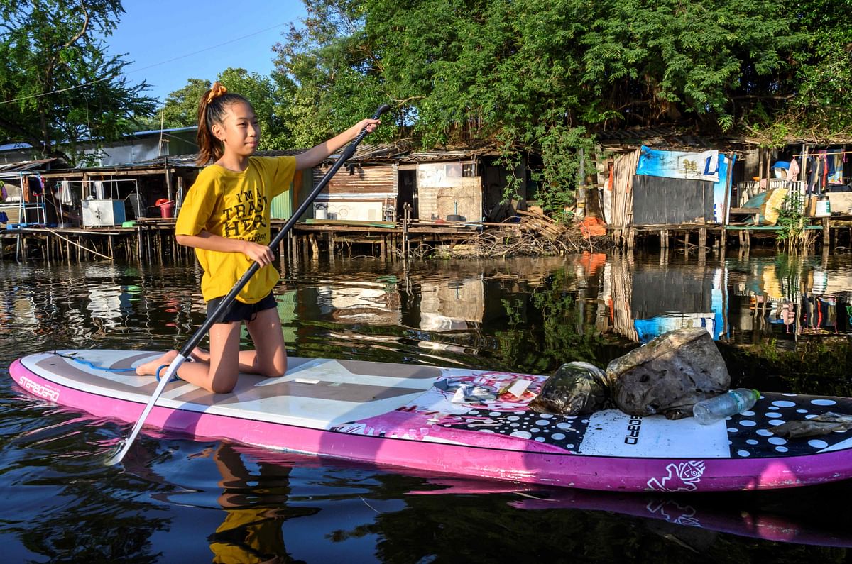 In this picture taken on 25 August 12-year-old Ralyn Satidtanasarn, known by her nickname Lilly, paddles to collect plastic waste in a canal in Bangkok. Photo: AFP
