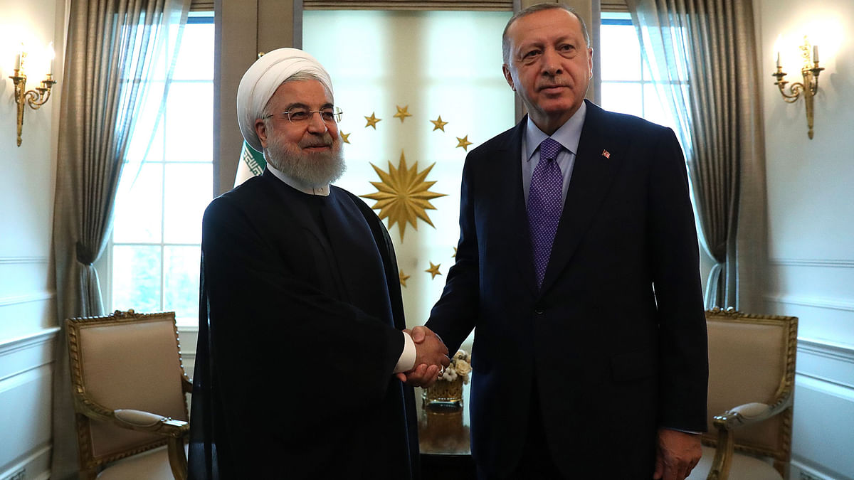 Turkish President Recep Tayyip Erdogan (R) and Iranian President Hassan Rouhani (L) shake hands before their meeting at the Presidential Palace in Ankara on Monday. Photo: AFP