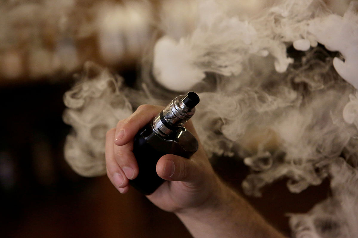 A man holds an electronic cigarette as he vapes at a Vape Shop in Monterrey. Photo: Reuters
