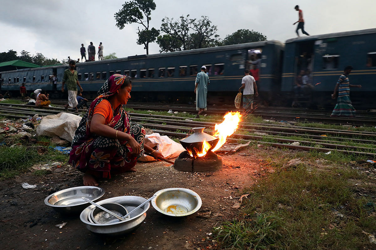 A homeless woman who lives beside railroad, cooks meal in Dhaka, Bangladesh, 16 September 2019. Photo: Reuters