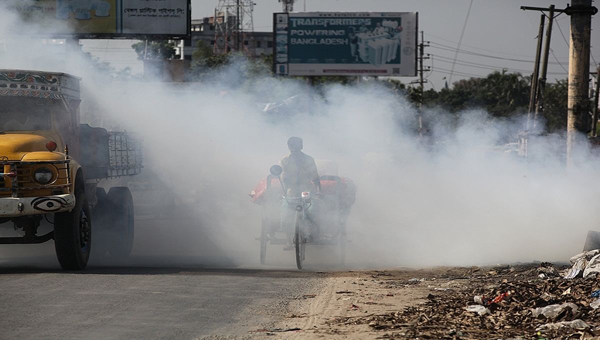 A rickshaw puller breathes in dangerous smoke created from burning of wastes. UNB File Photo