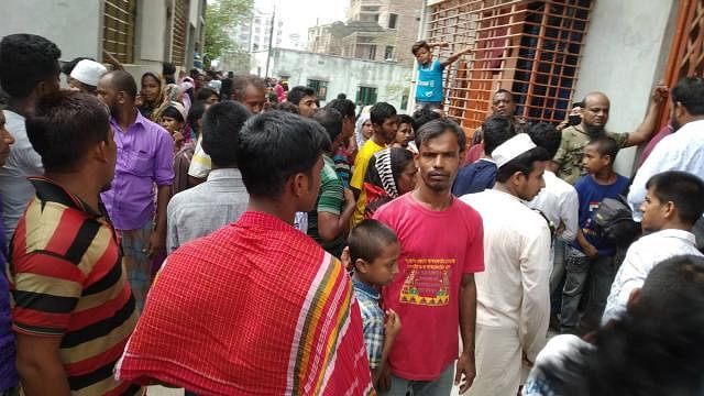 People gather outside the house where a woman and two of her daughters were hacked to death. Photo: Prothom Alo