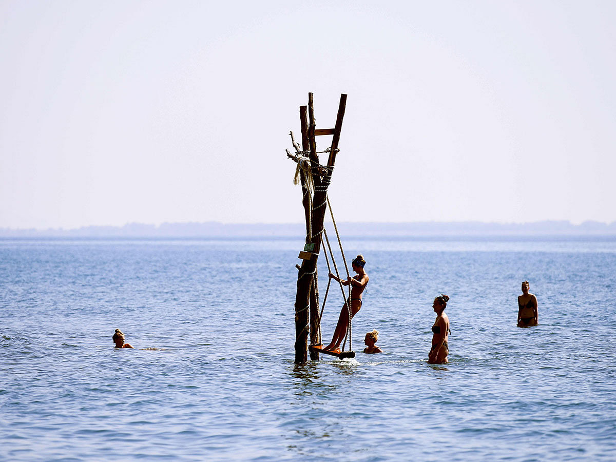 A girl plays on a swing installed in the sea near coastal town of Sh‘ngjin, Albania on 17 September 2019. Photo: AFP