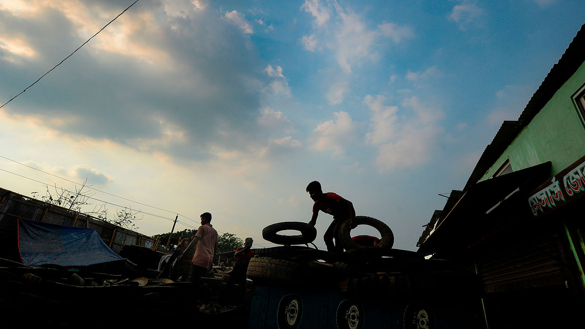 Labourers load pieces of used tyres in a truck in Dhaka on 1 September 2019. Photo: AFP