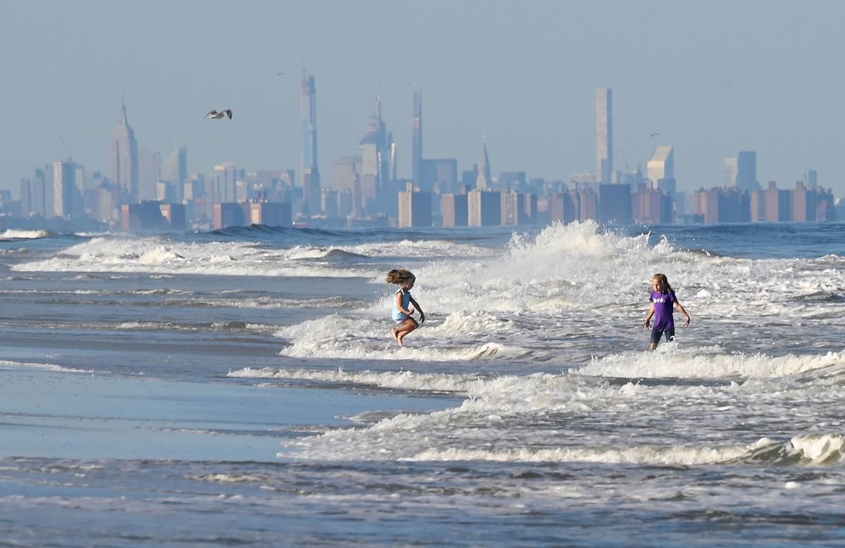 Children jump in the waves at the beach in front of the skyline of Lower Manhattan on 17 September 2019 in Long Branch, New Jersey. Photo: AFP