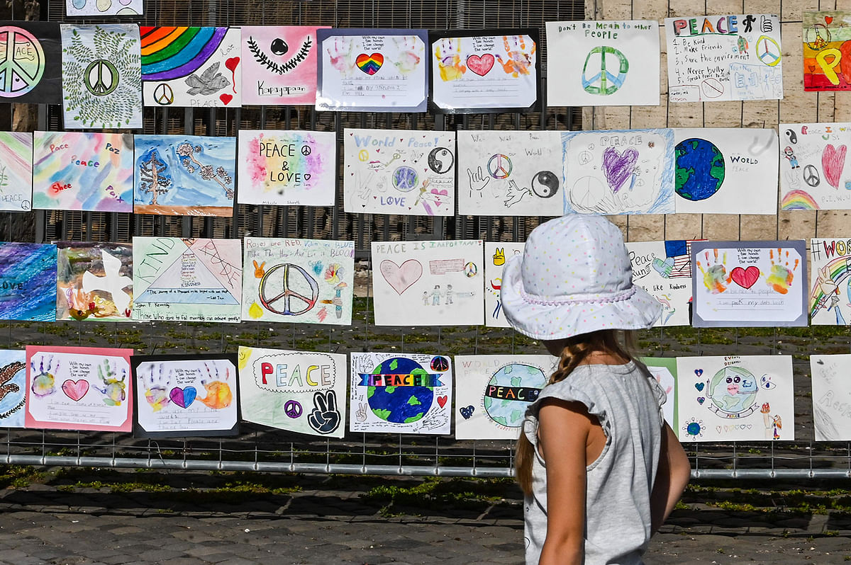 A child views on 20 September, 2019 of `Colors of Peace`, a series of children`s drawing exhibited in front of the Colosseum monument in Rome to mark the United Nations International Day of Peace on 21 September. Photo: AFP