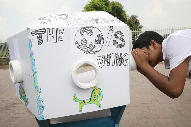 A student peeps inside a dummy bioscope to see imminent danger of climate change. Photo: Prothom Alo