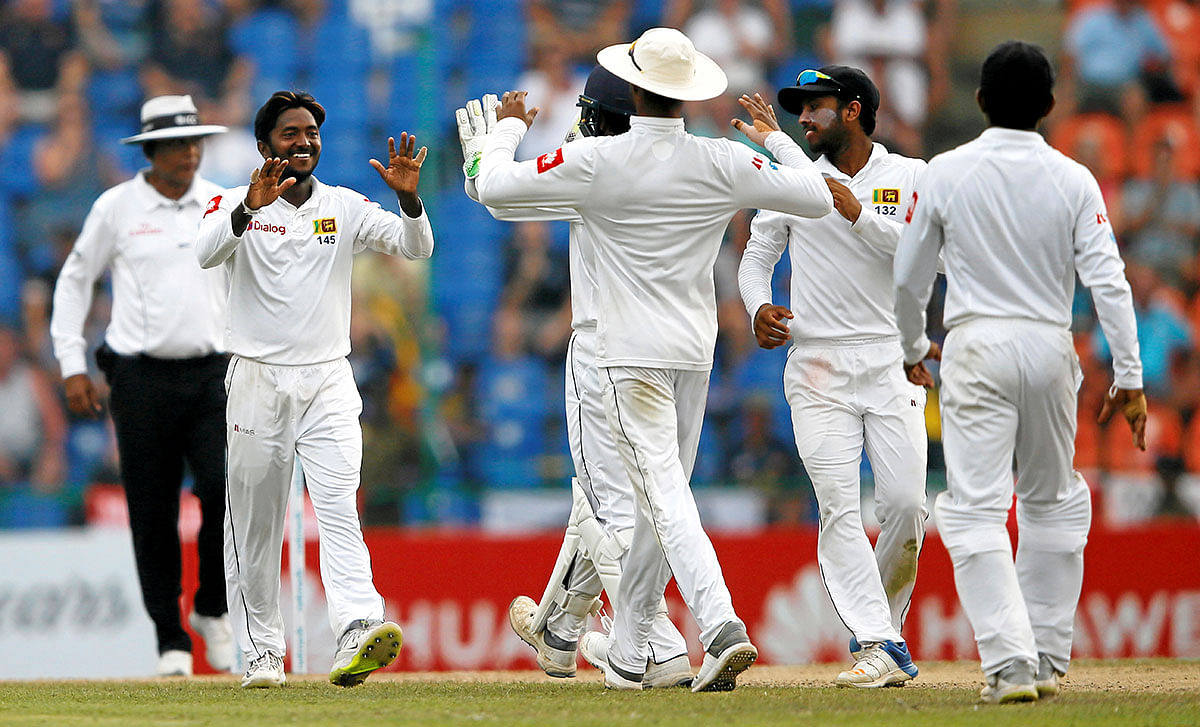 Sri Lanka`s Akila Dananjaya (L) celebrates with his teammates after taking the wicket of England`s captain Joe Root (not pictured). Reuters file photo