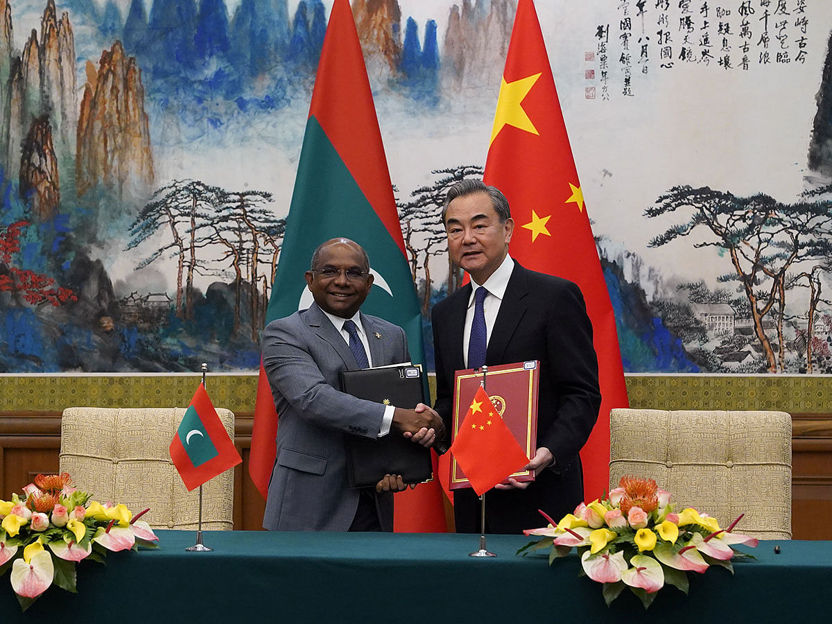 Chinese foreign minister Wang Yi and Maldives foreign minister Abdulla Shahid shake hands and hold the signed agreements during the signing ceremony at the end of the meeting at Diaoyutai State Guesthouse, in Beijing, China on 20 September 2019. Photo: Reuters