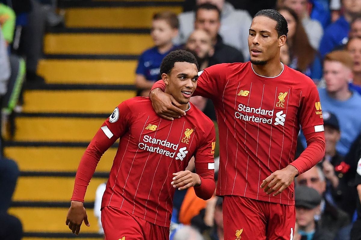 Liverpool`s English defender Trent Alexander-Arnold (L) celebrates with Liverpool`s Dutch defender Virgil van Dijk (R) after scoring the opening goal during the English Premier League football match between Chelsea and Liverpool at Stamford Bridge in London on Sunday. Photo: AFP