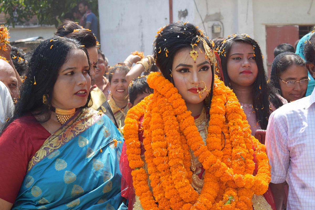 In this handout photograph taken on 21 September 2019, relatives of groom Tariqul Islam welcome bride Khadiza Akter Khushi (C) with a floral wreath as she arrives to groom`s house during their wedding in Meherpur. Photo: AFP