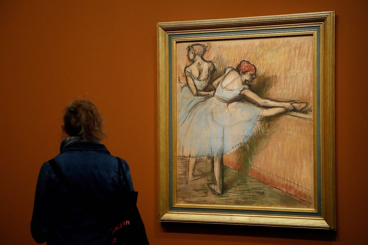 A person looks at the painting entitled `Dancers at the helm` (Danseuses a la barre) made around 1900 by French painter Edgar Degas, during the press visit of the exhibition `Degas at the Opera` at the Museum of Orsay, in Paris, on 20 September 2019 in Paris. Photo: AFP