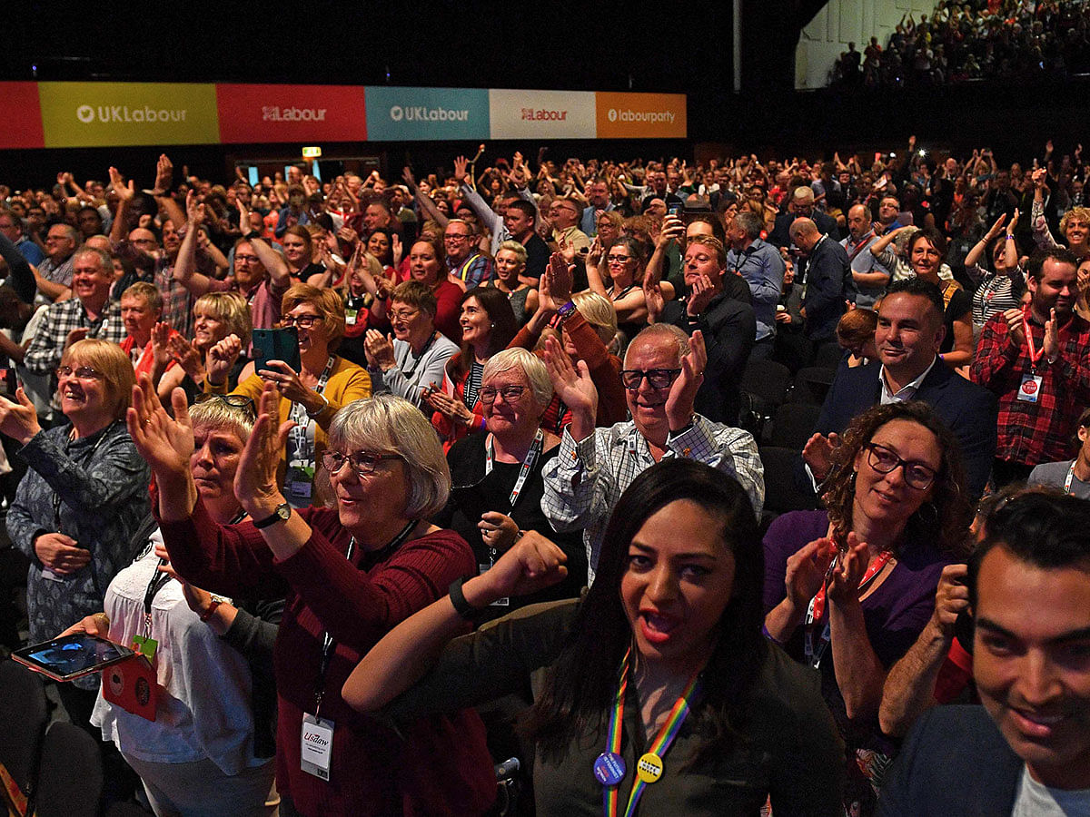 Delegates in the hall applaud as Britain`s main opposition Labour Party Leader Jeremy Corbyn delivers a speech on stage moments after hearing to the news that the Supreme Court had ruled against the government and that the suspension of the UK parliament was `unlawful`, on stage during the annual Labour Party conference in Brighton, on the south coast of England on 24 September 2019. Photo: AFP