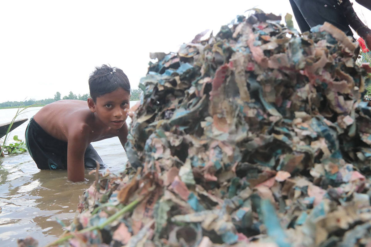A child stares at the banknotes shredded into pieces. Soel Rana took this photo from Shahjahanpur in Bogura on 24 September, 2019.